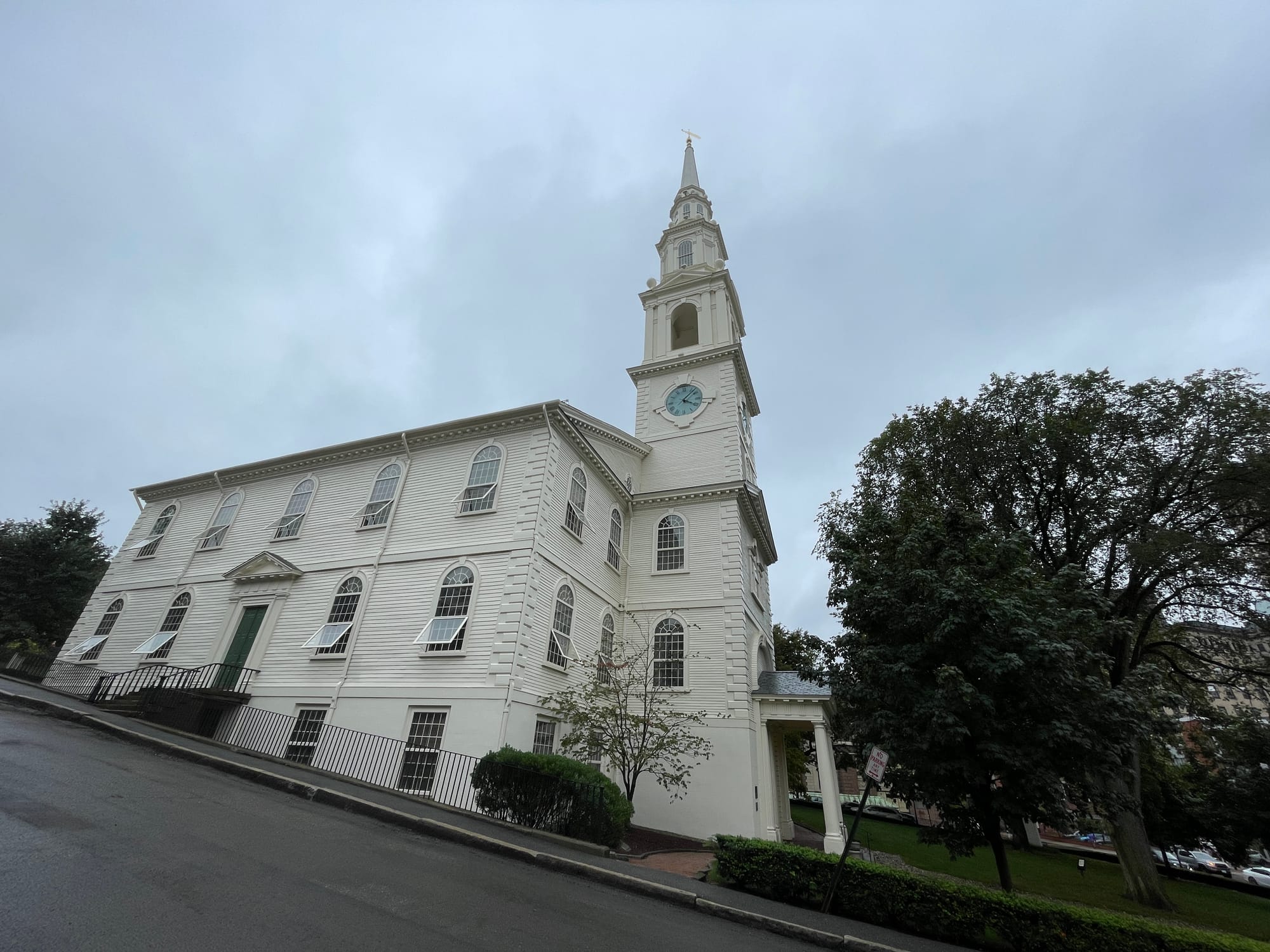 A white New England church with a tall clock-tower steeple