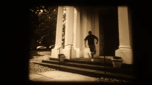 A 16mm frame of the character running up the steps into a white-columned church