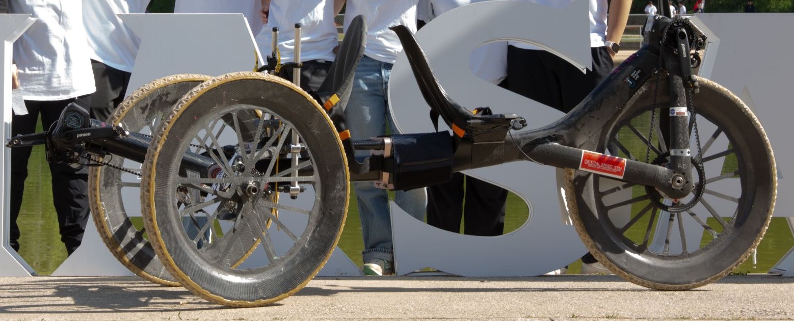 Rider steering the RISD Rover along a riverfront path